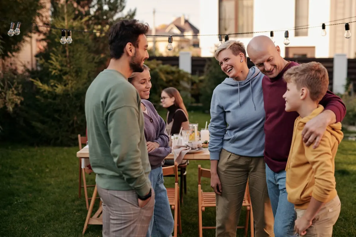 Family gathered at an evening backyard party with string lights