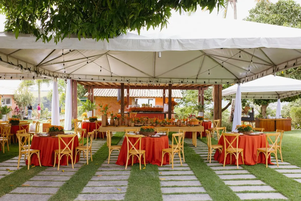 Tables and chairs set up under a white canopy for an outdoor celebration