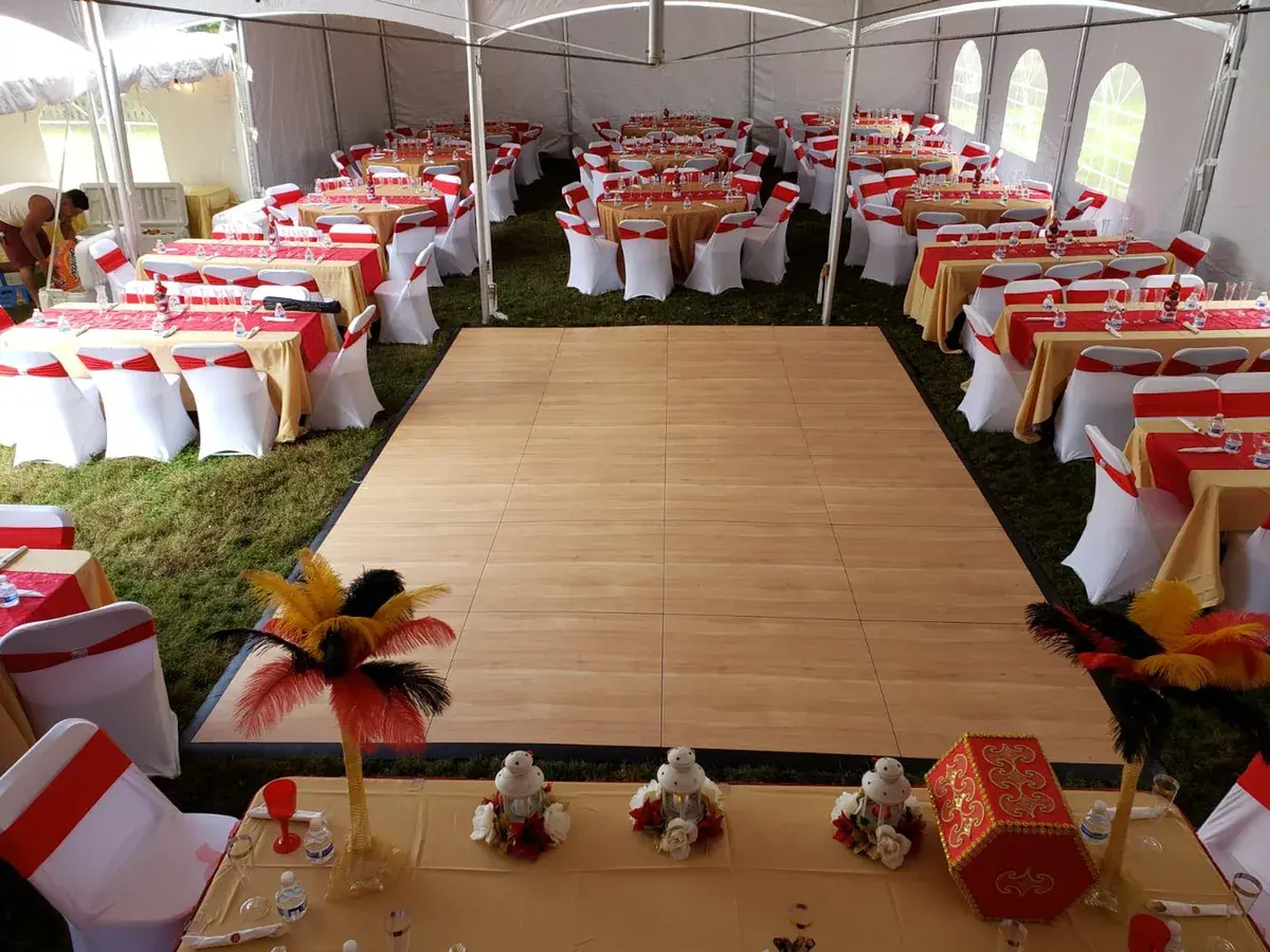 Dance floor set up inside a tent surrounded by decorated reception tables