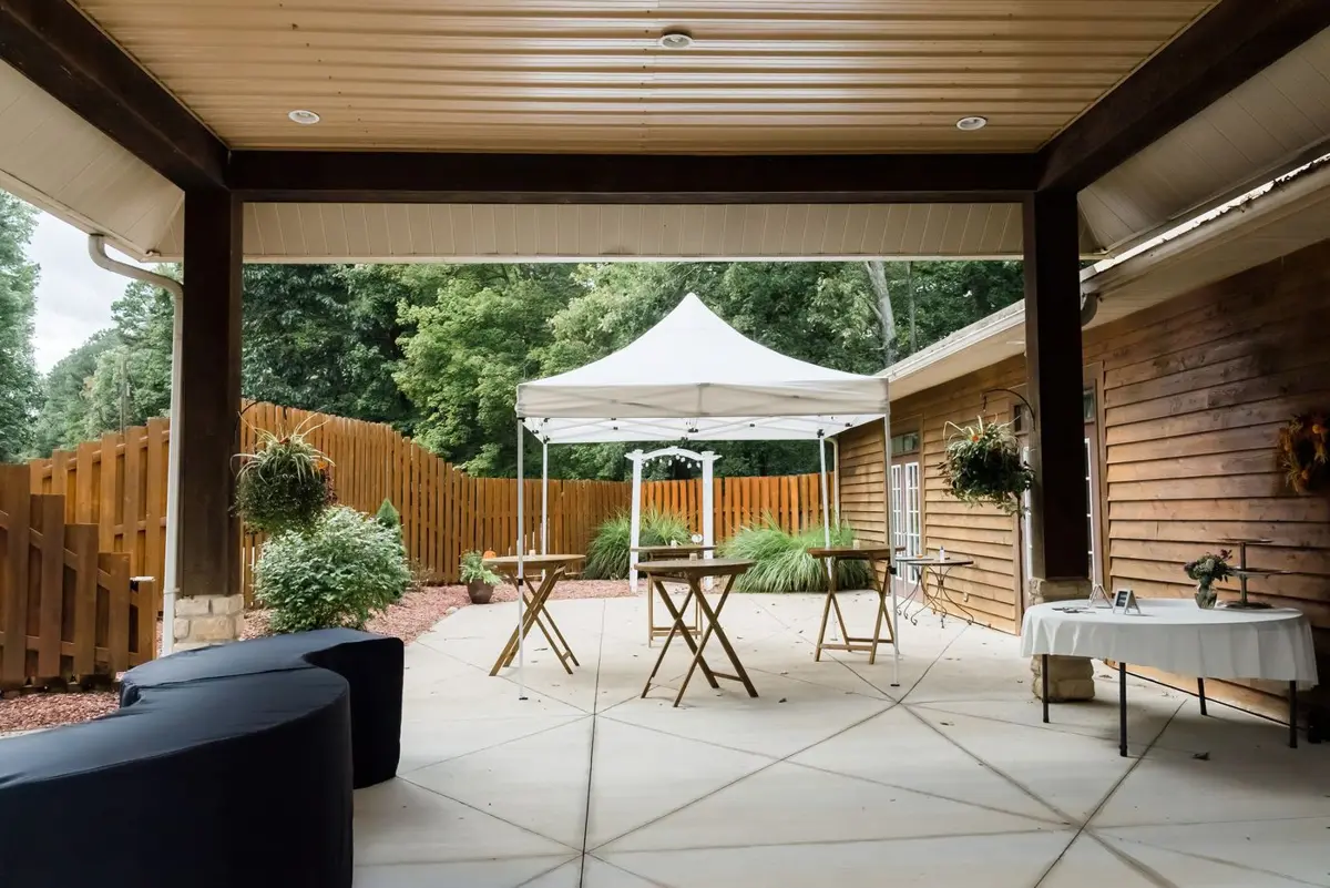 White tent set up on a paved patio with tables