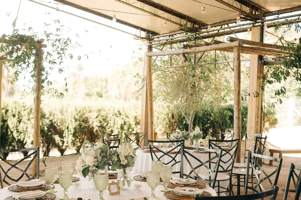 Reception tables and chairs arranged under an outdoor canopy