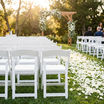 White resin folding chairs — outdoor wedding ceremony setup, rows of pure white chairs